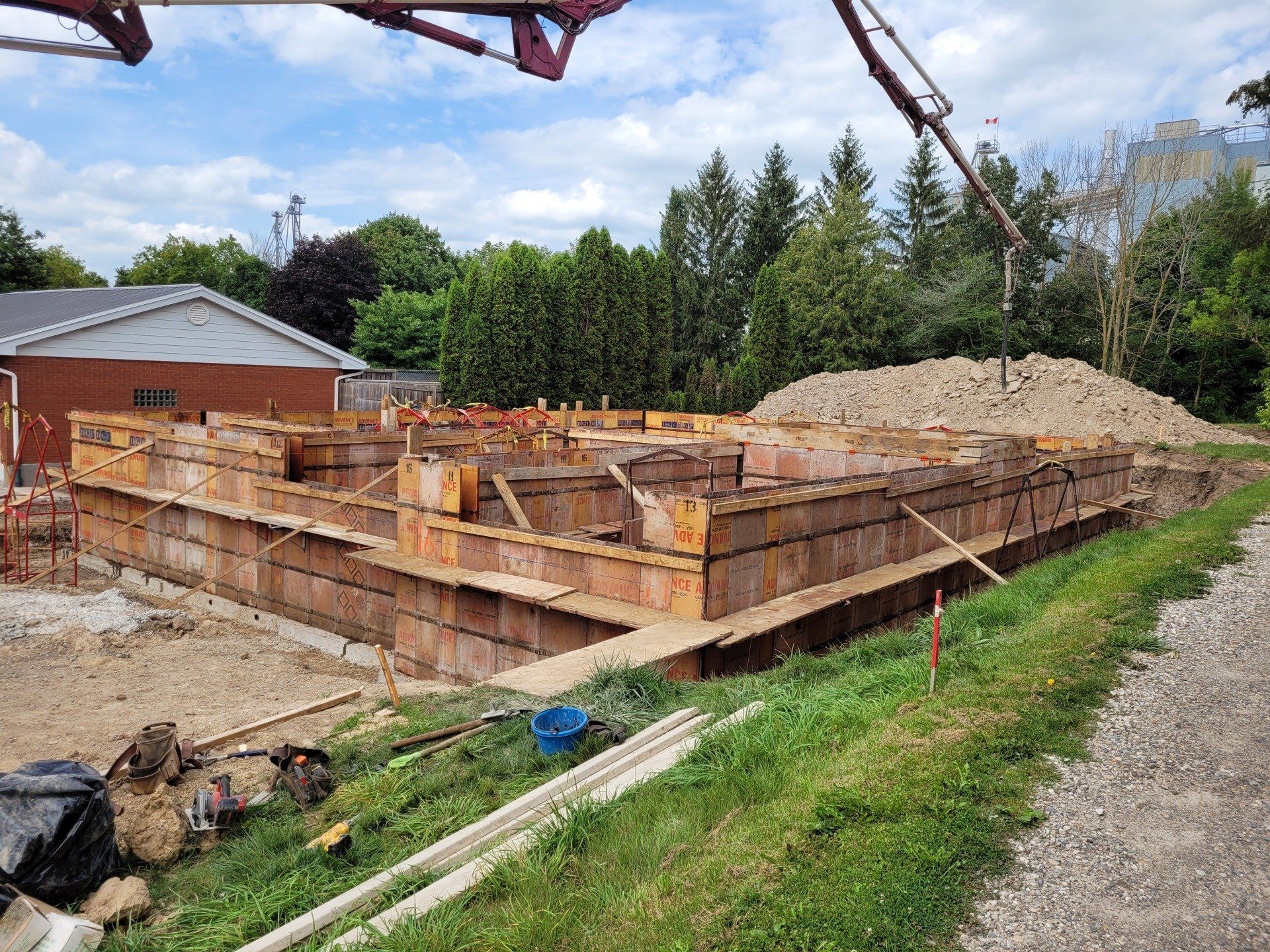 A large pile of dirt is sitting next to a house under construction.