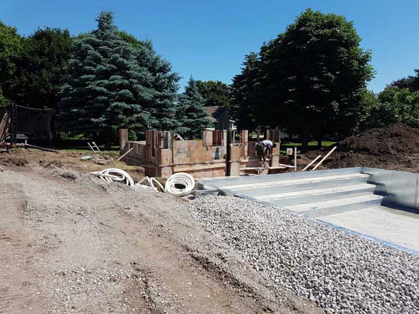 A construction site with a lot of gravel and trees in the background.