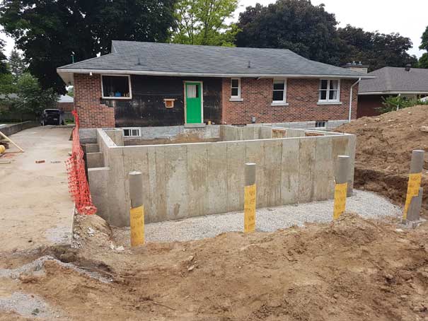 A brick house with a green door is under construction.