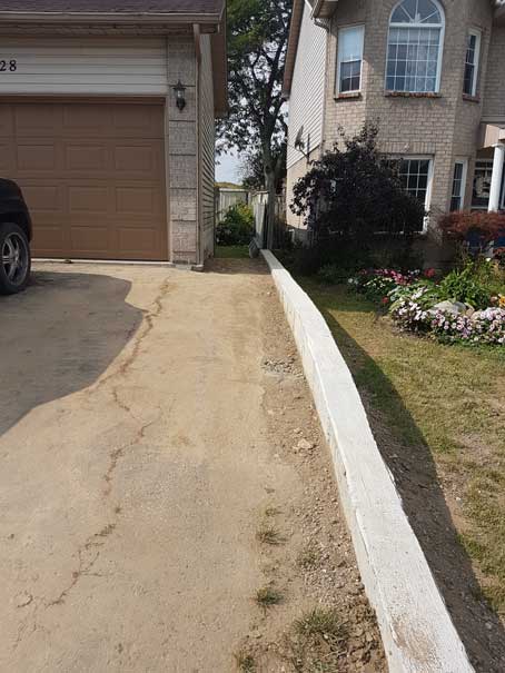 A car is parked in a driveway next to a house.