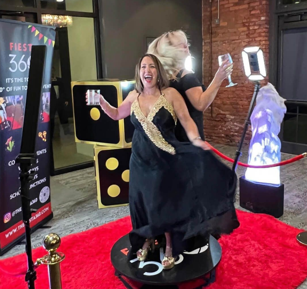 Two women are posing for a picture on a red carpet.