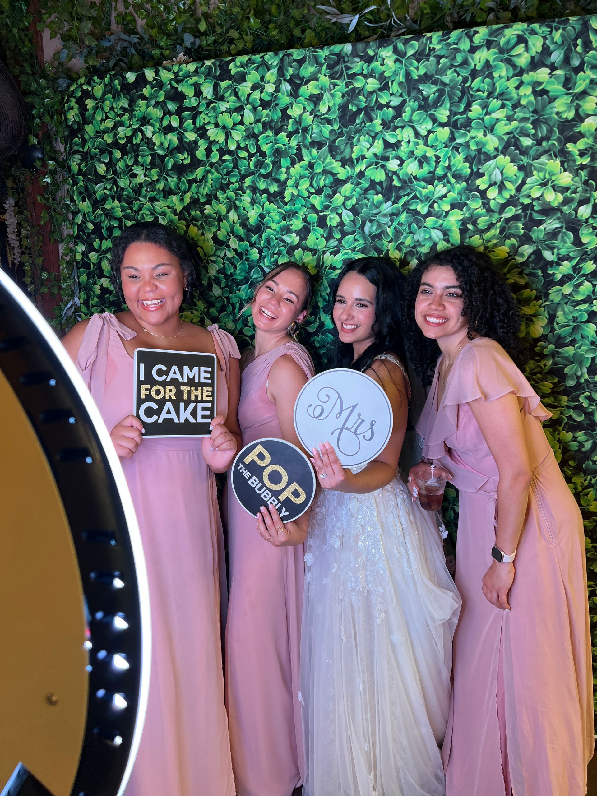 Guests posing at Fiesta 360 photo booth wedding with greenery backdrop Tampa