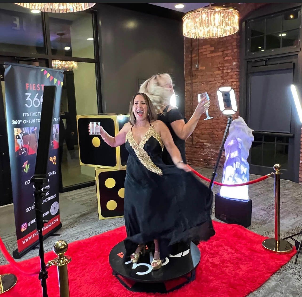 Two women are posing for a picture on a red carpet.