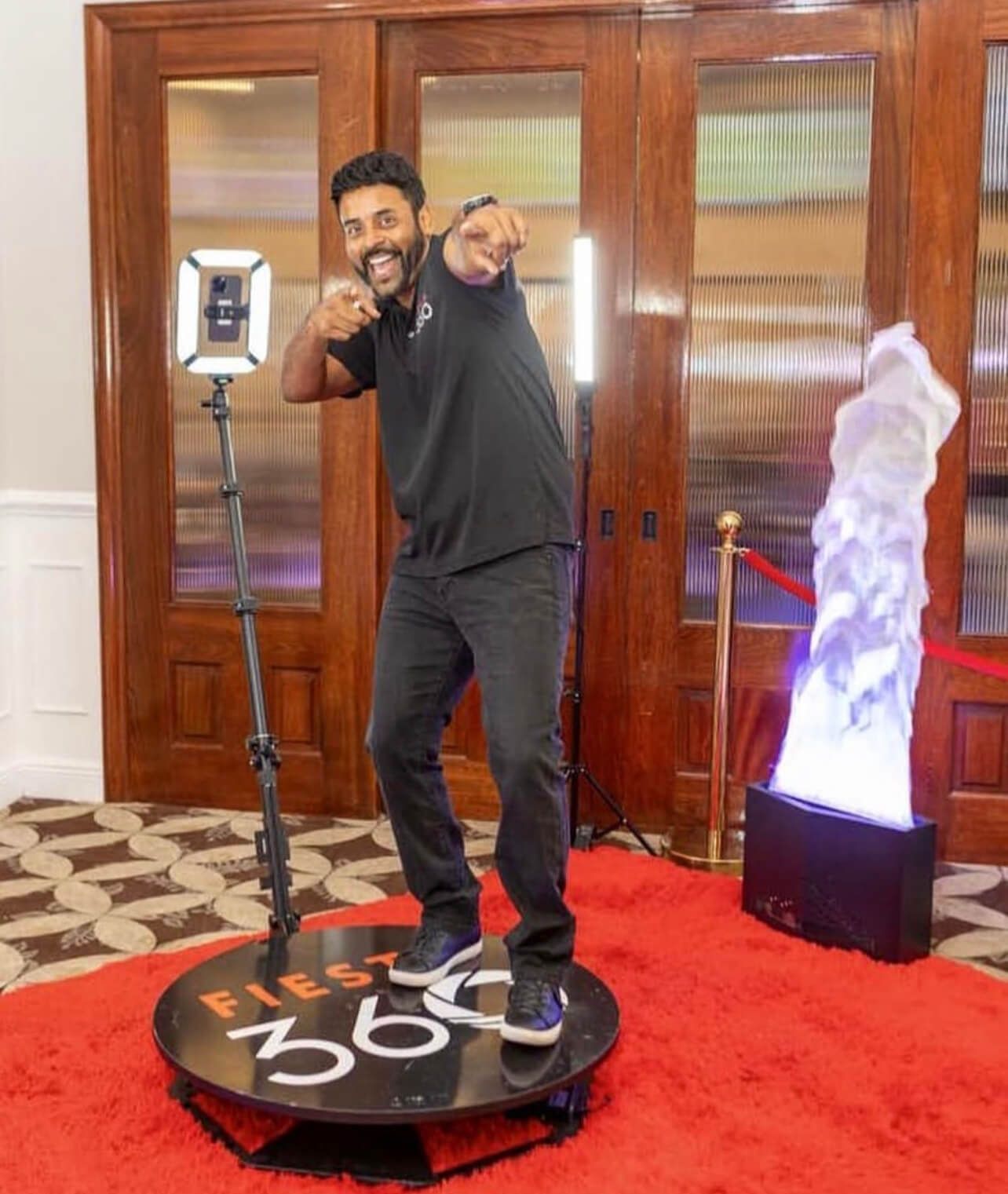 A man is standing on a first 360 photo booth