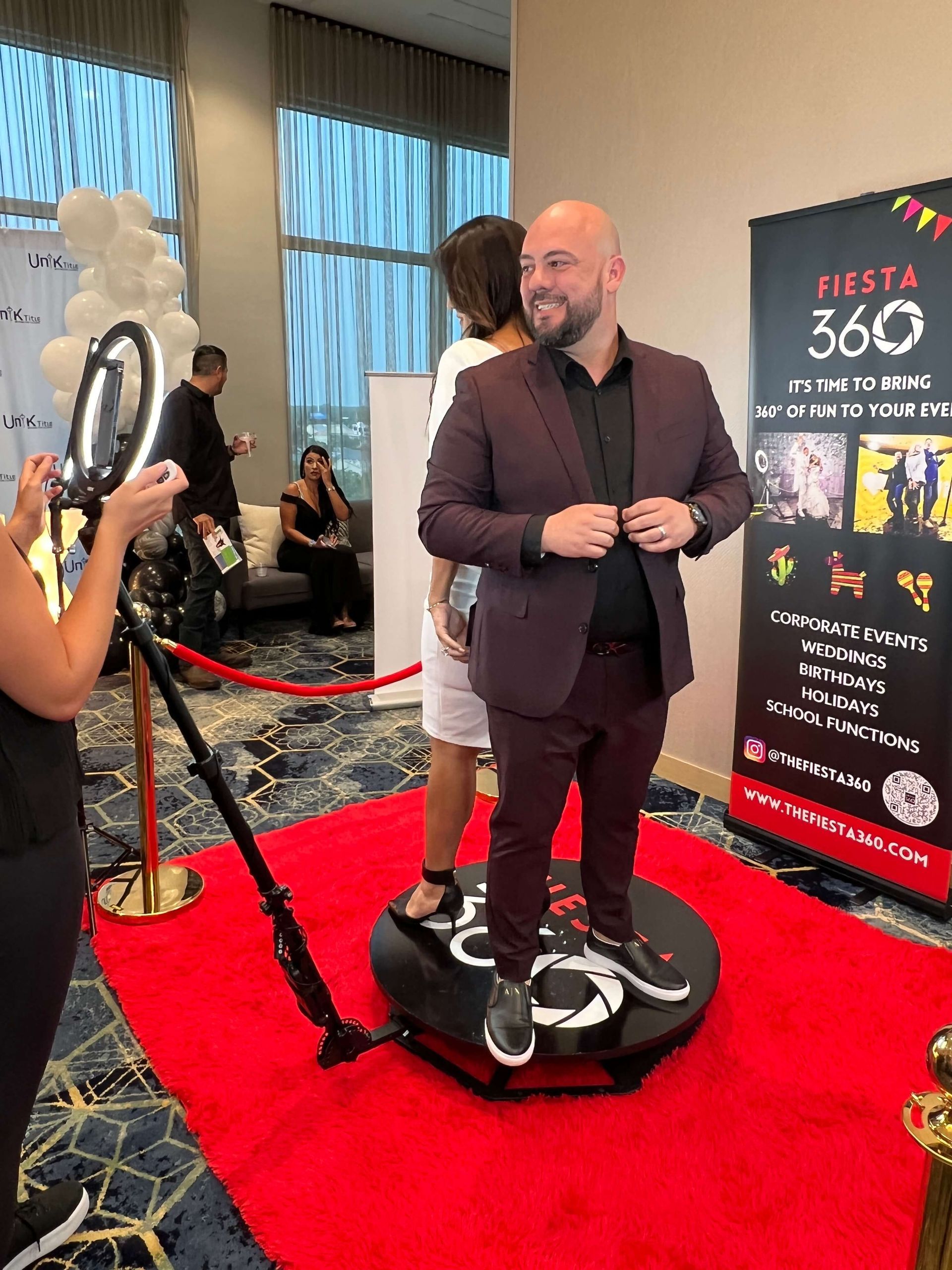 A man in a suit is standing on a red carpet.