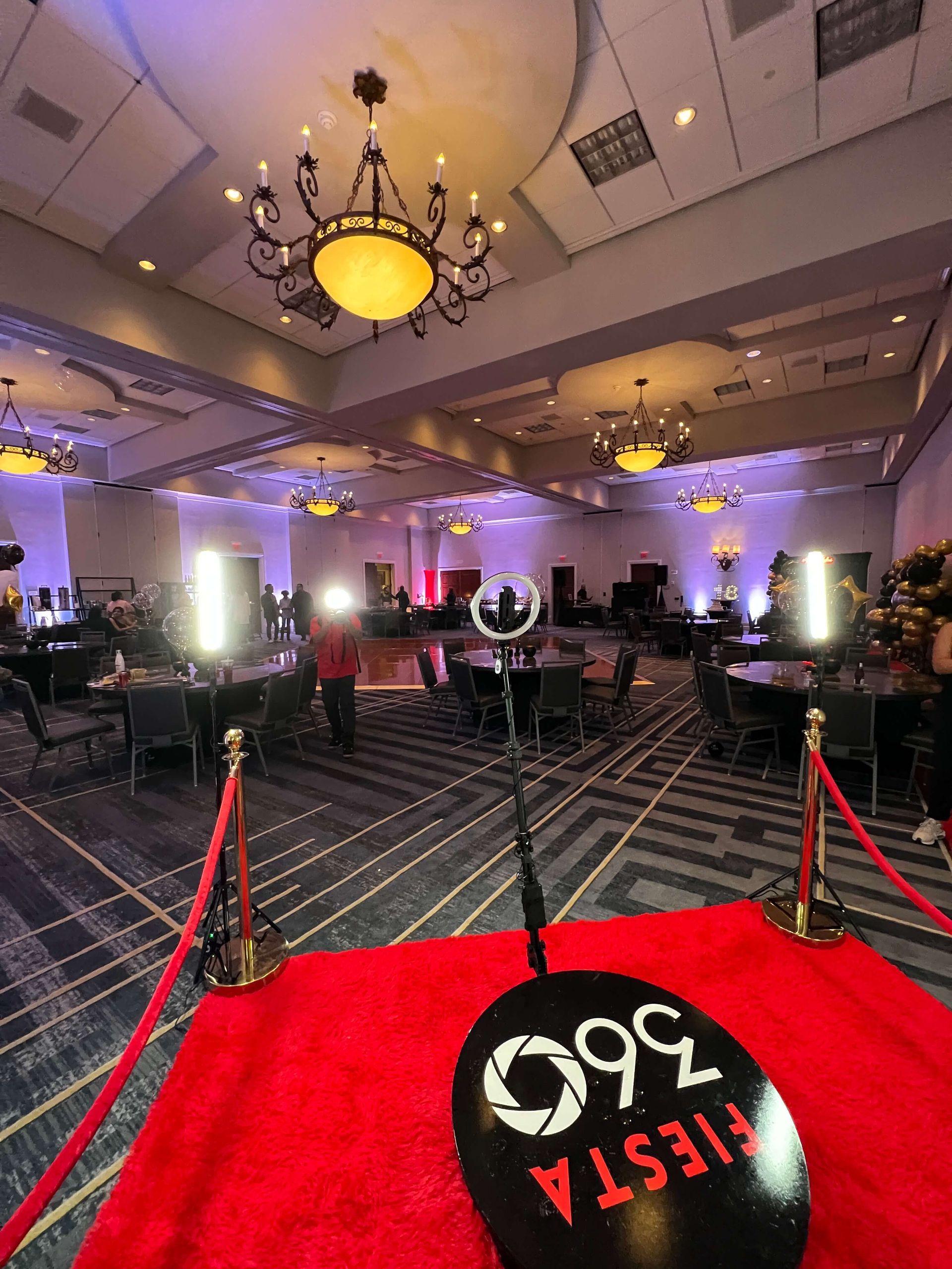 A microphone is sitting on a red carpet in a large room.