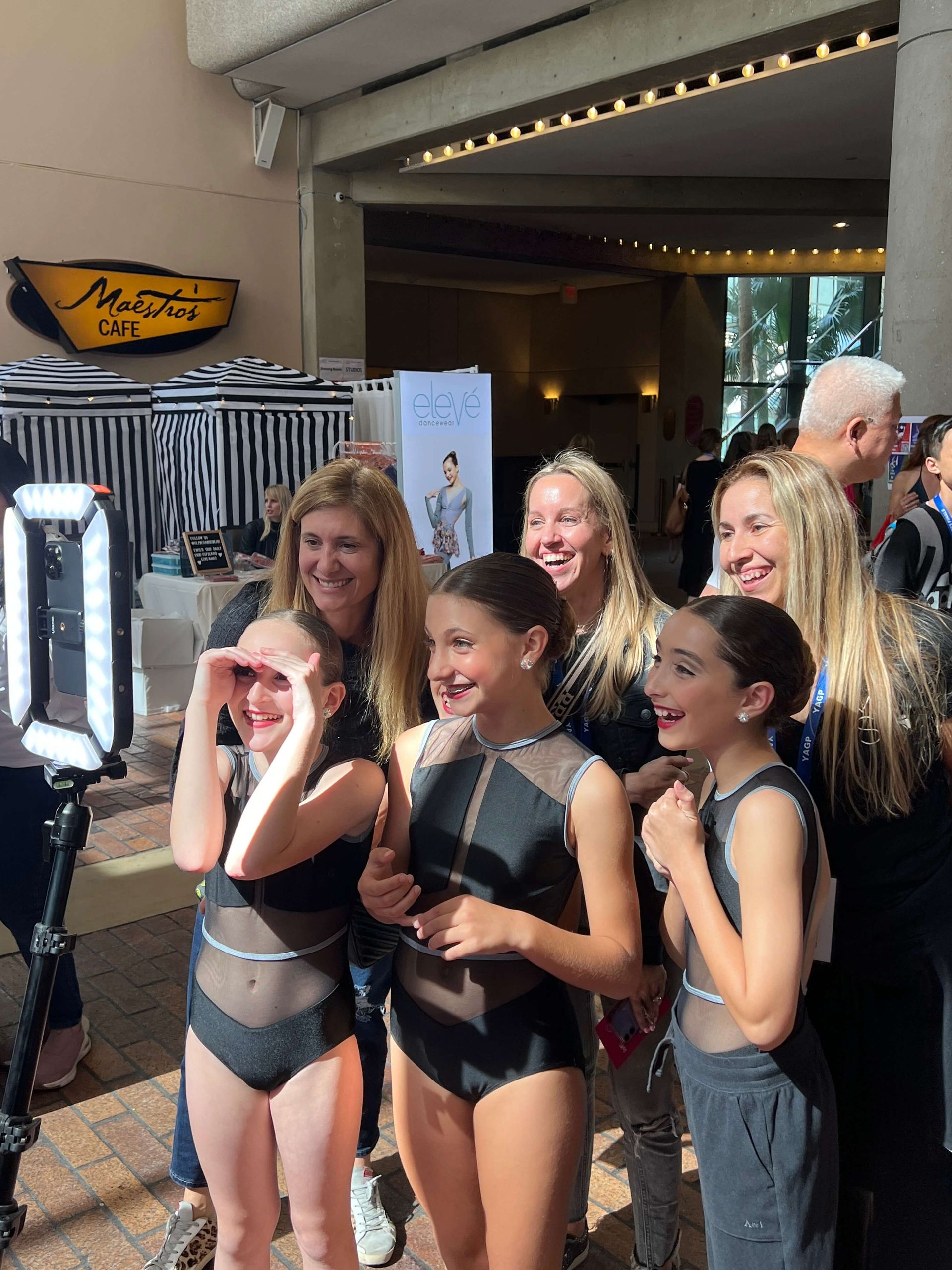 A group of young girls are posing for a picture in front of a building.