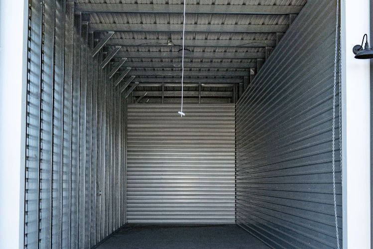 A trailer is sitting in the middle of a dirt field.