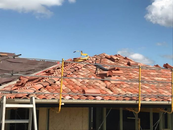 A Roof That Is Being Worked On With A Ladder In The Foreground — Lance Ward Roof Tiling in Orange, NSW