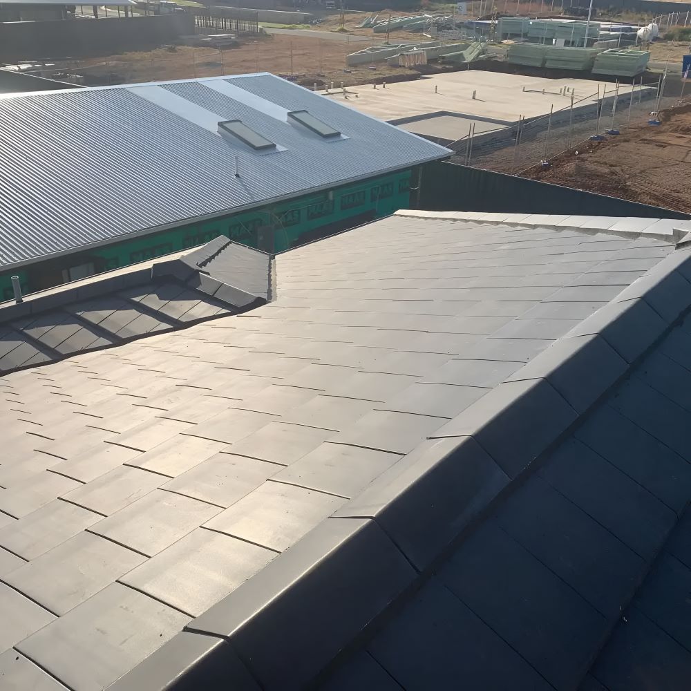 A Building With A Roof That Has A Lot Of Tiles On It — Lance Ward Roof Tiling in Forbes, NSW