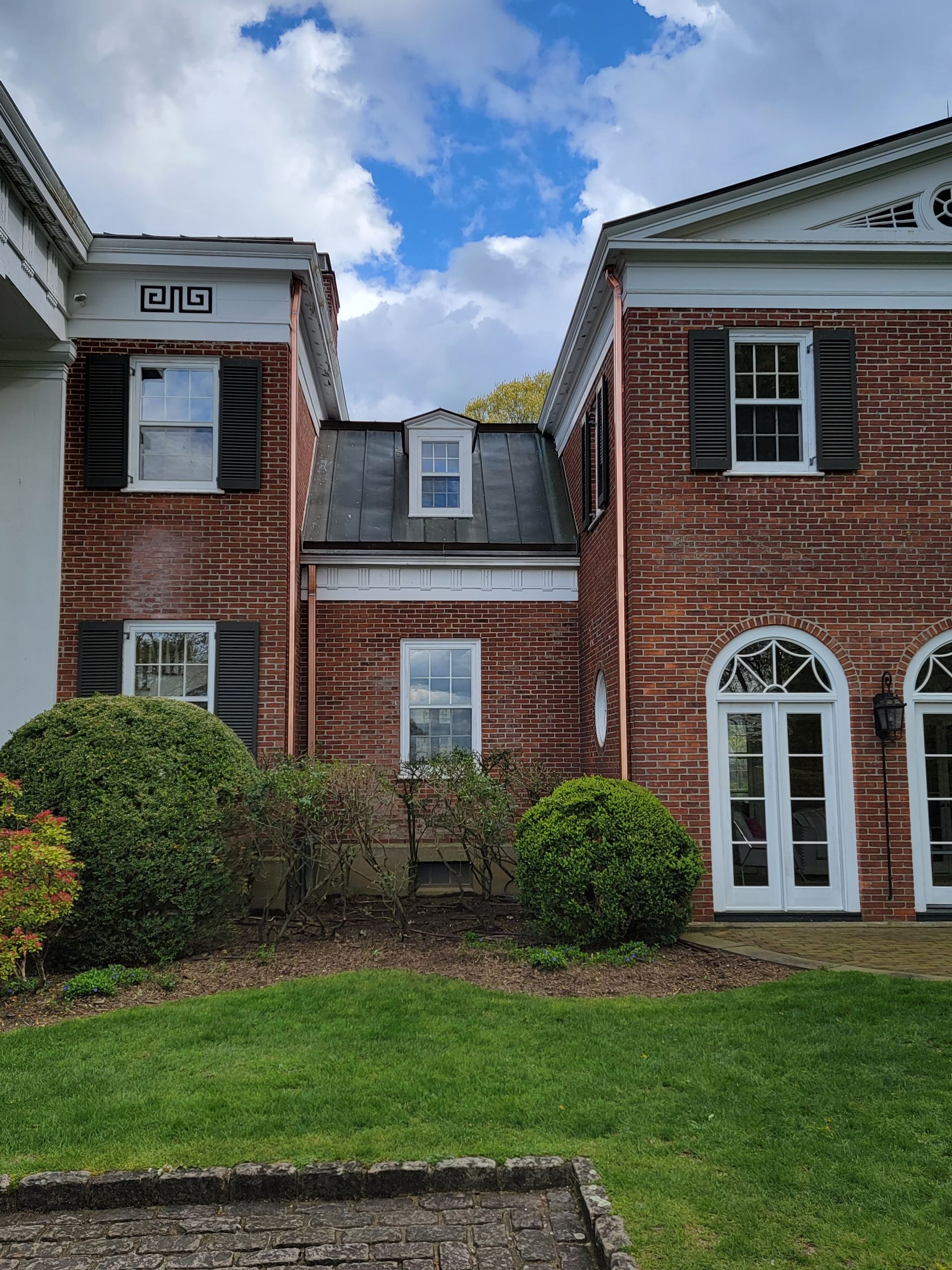 A large brick building with a lot of windows and shutters