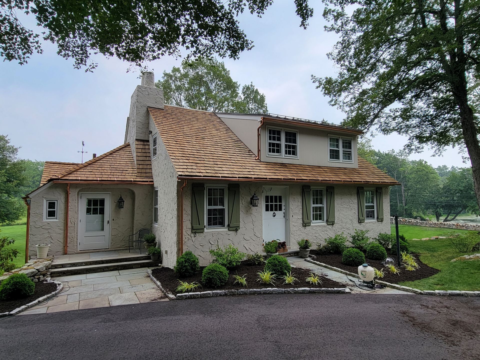 A white house with a wooden roof and shutters