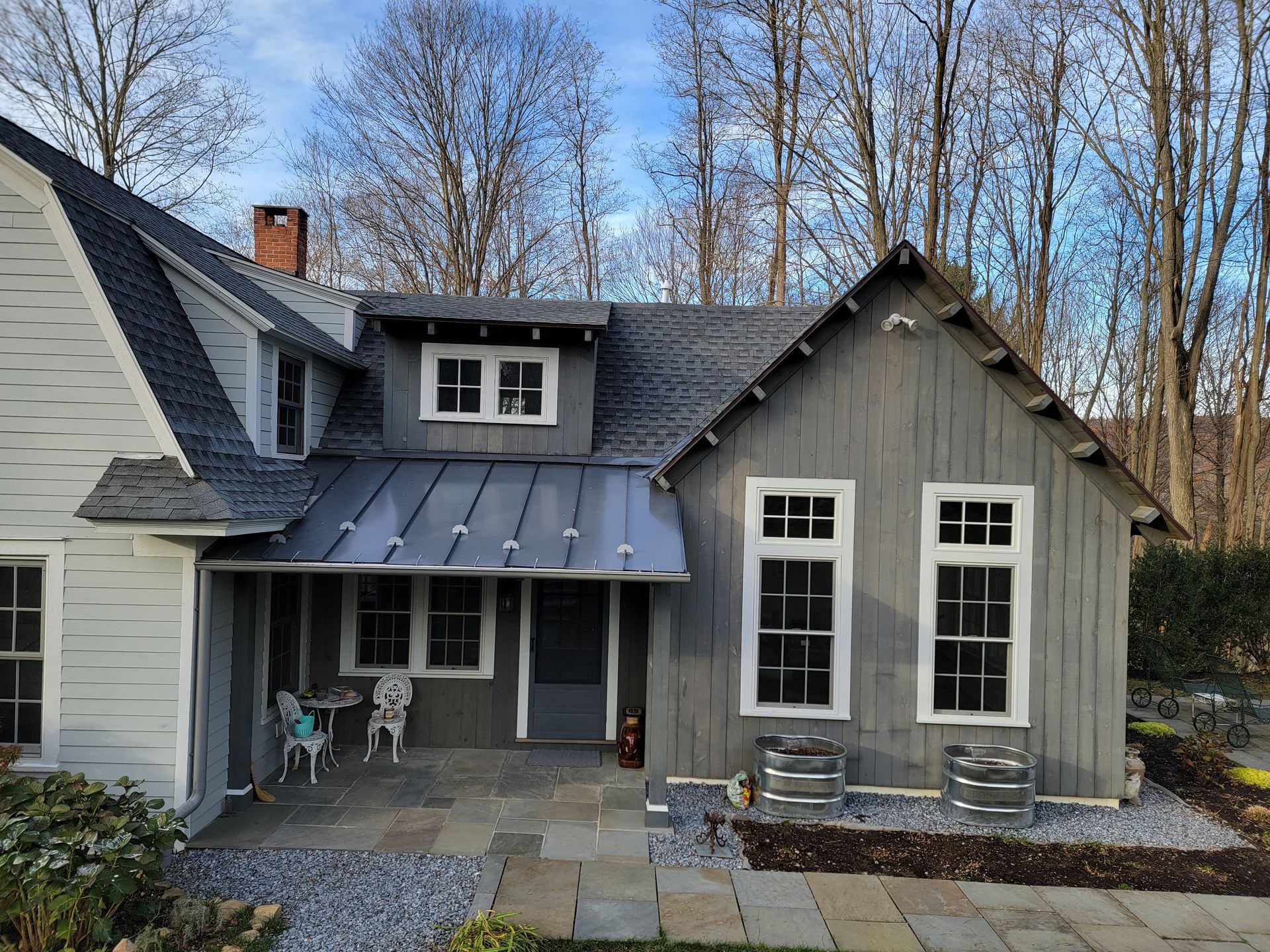 A gray and white house with a metal roof