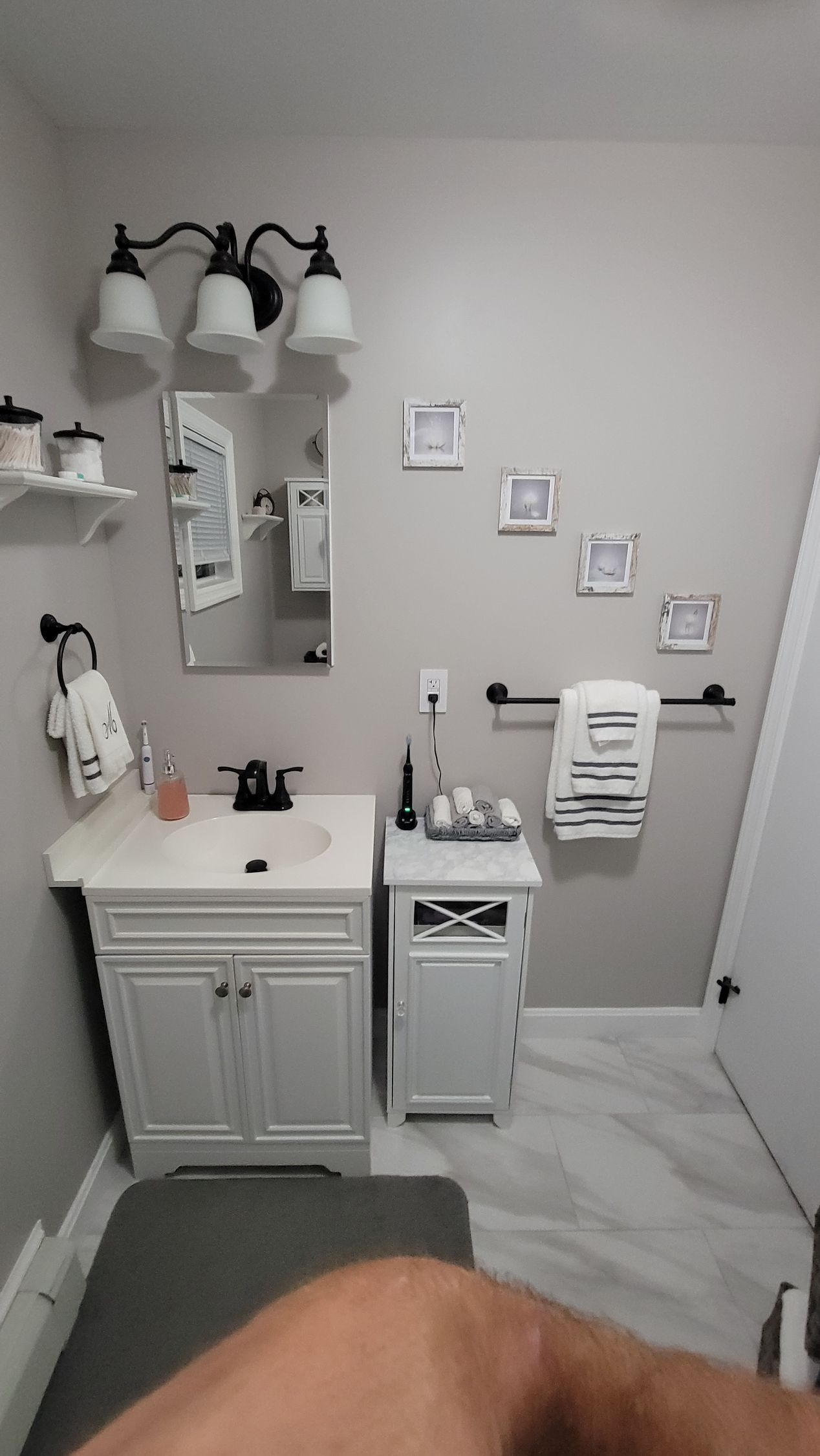 A bathroom with a sink , mirror , and towels.