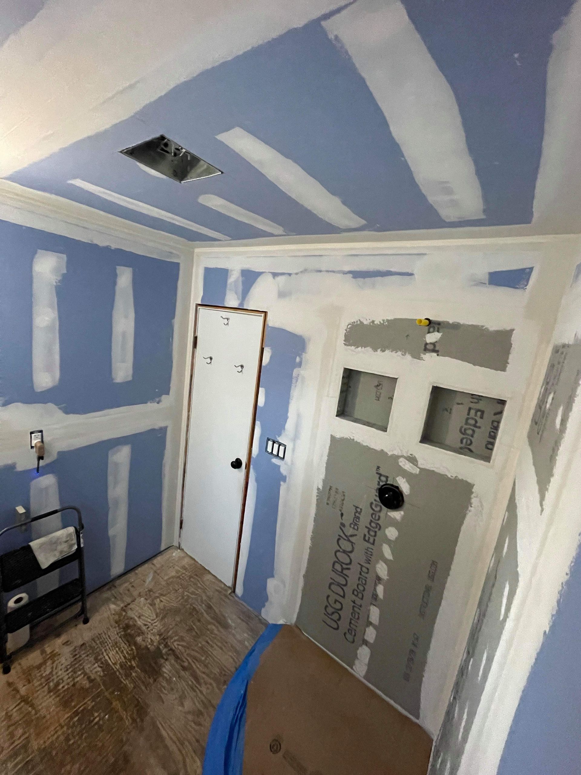 A room with blue walls and white trim is being remodeled.