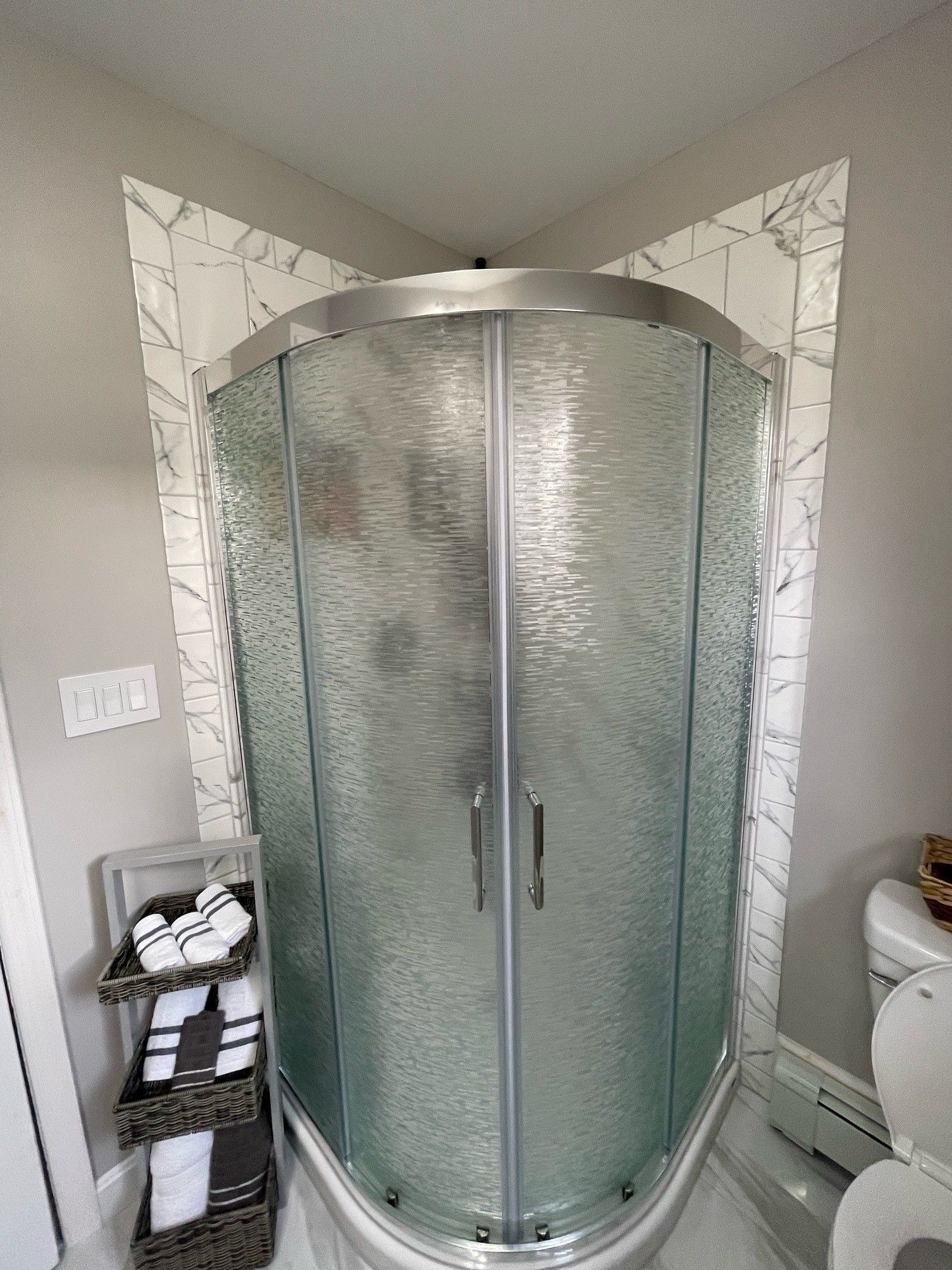 A bathroom with a shower stall and a toilet.