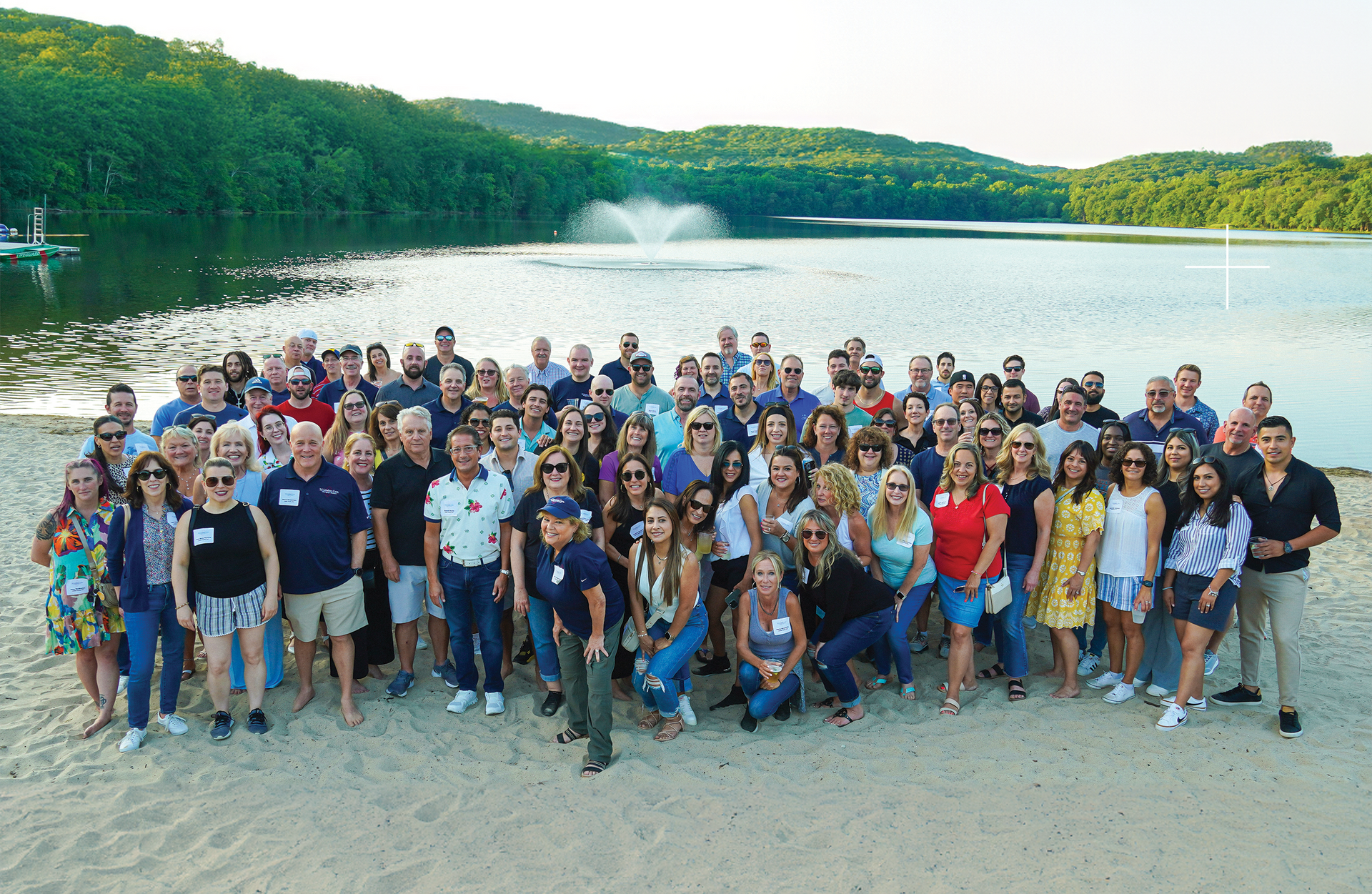 A large group of people are posing for a picture under a tree.