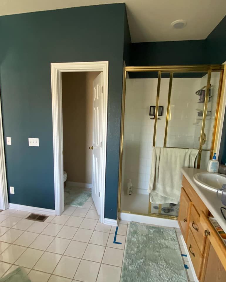 A bathroom with a walk in shower and a sink