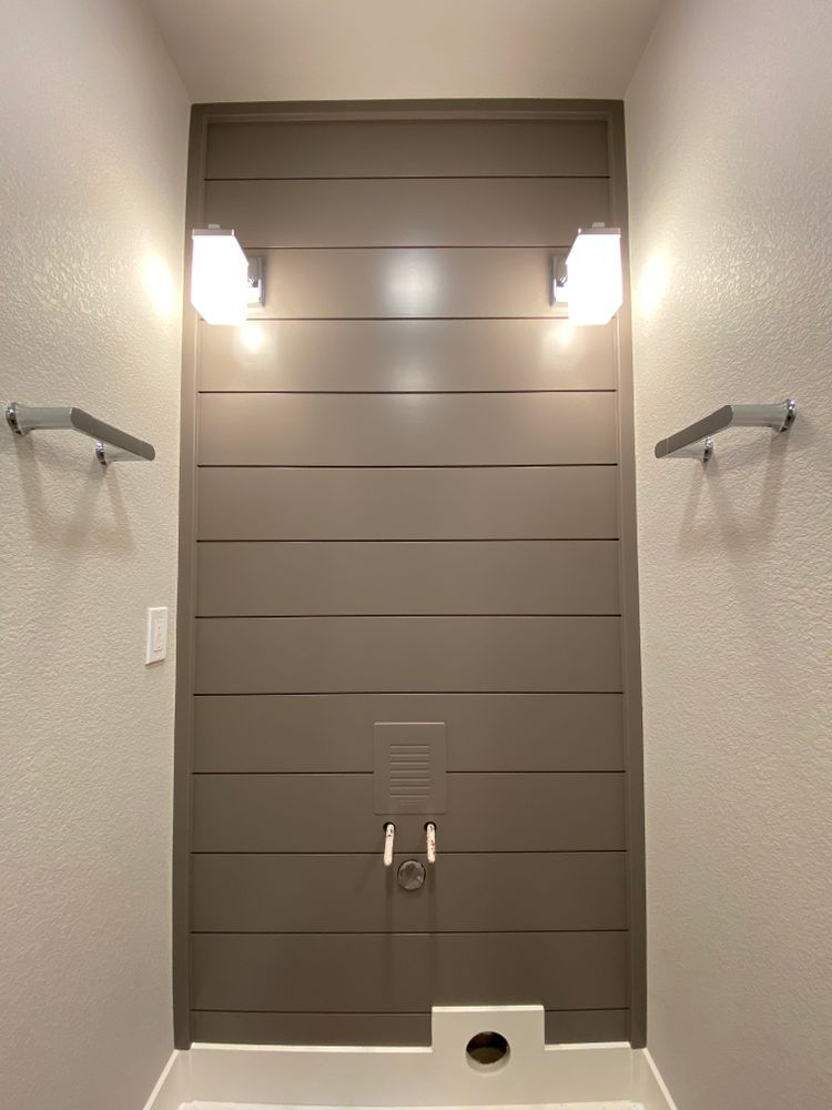 A bathroom with a gray wall and a sink.
