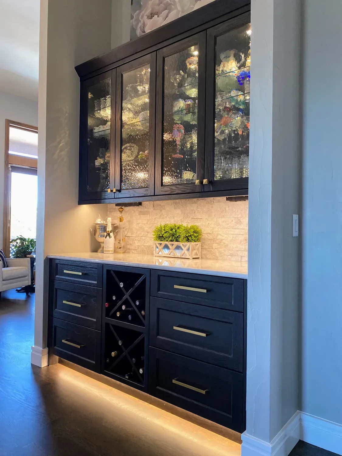 A kitchen with black cabinets and a wine rack.