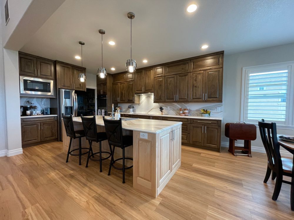 A kitchen with a large island in the middle of it and wooden floors.