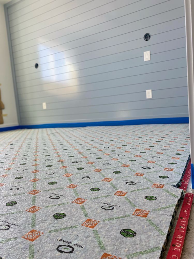 A close up of a carpet in a room with a blue wall.