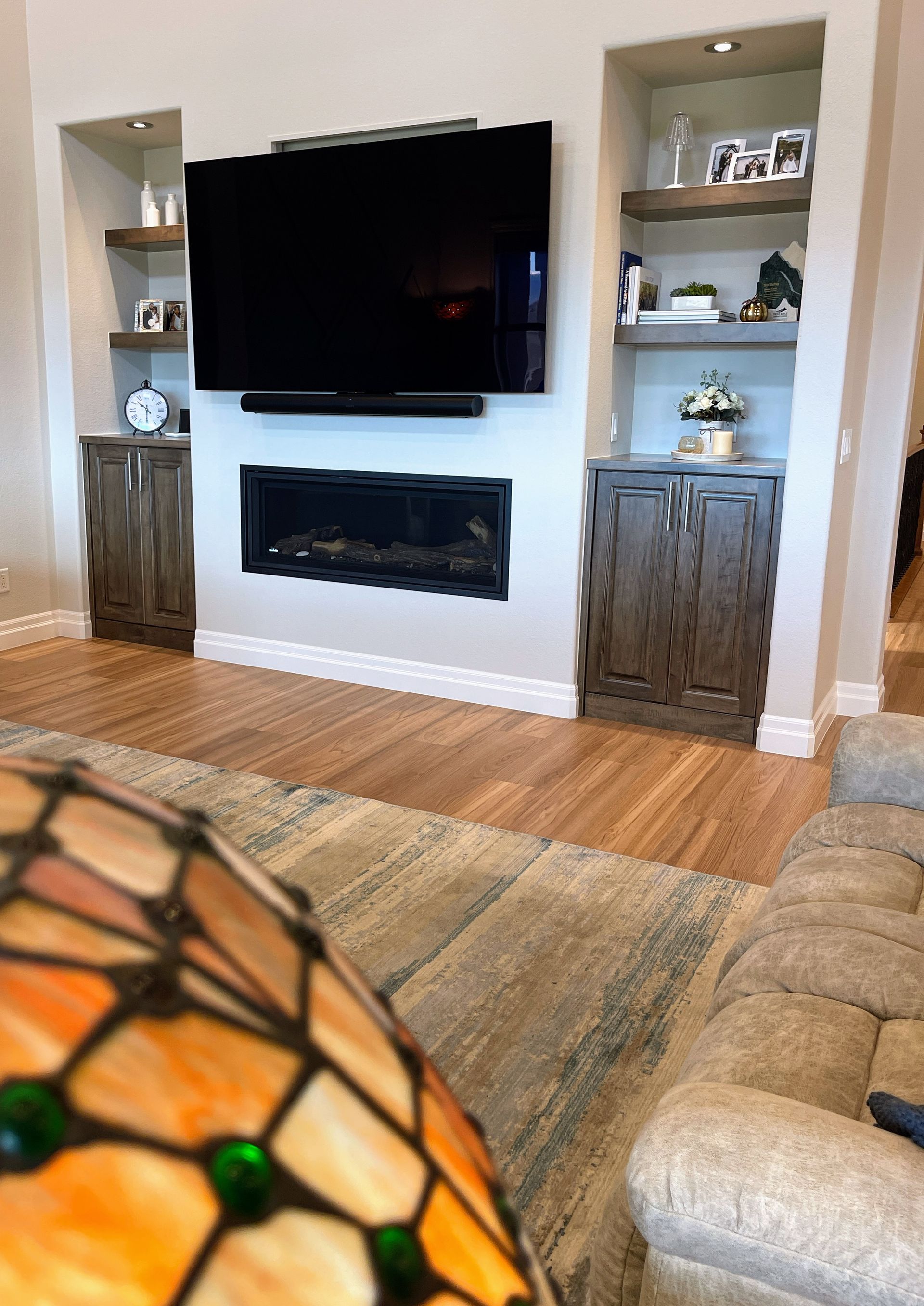 A living room with a fireplace and a flat screen tv on the wall.