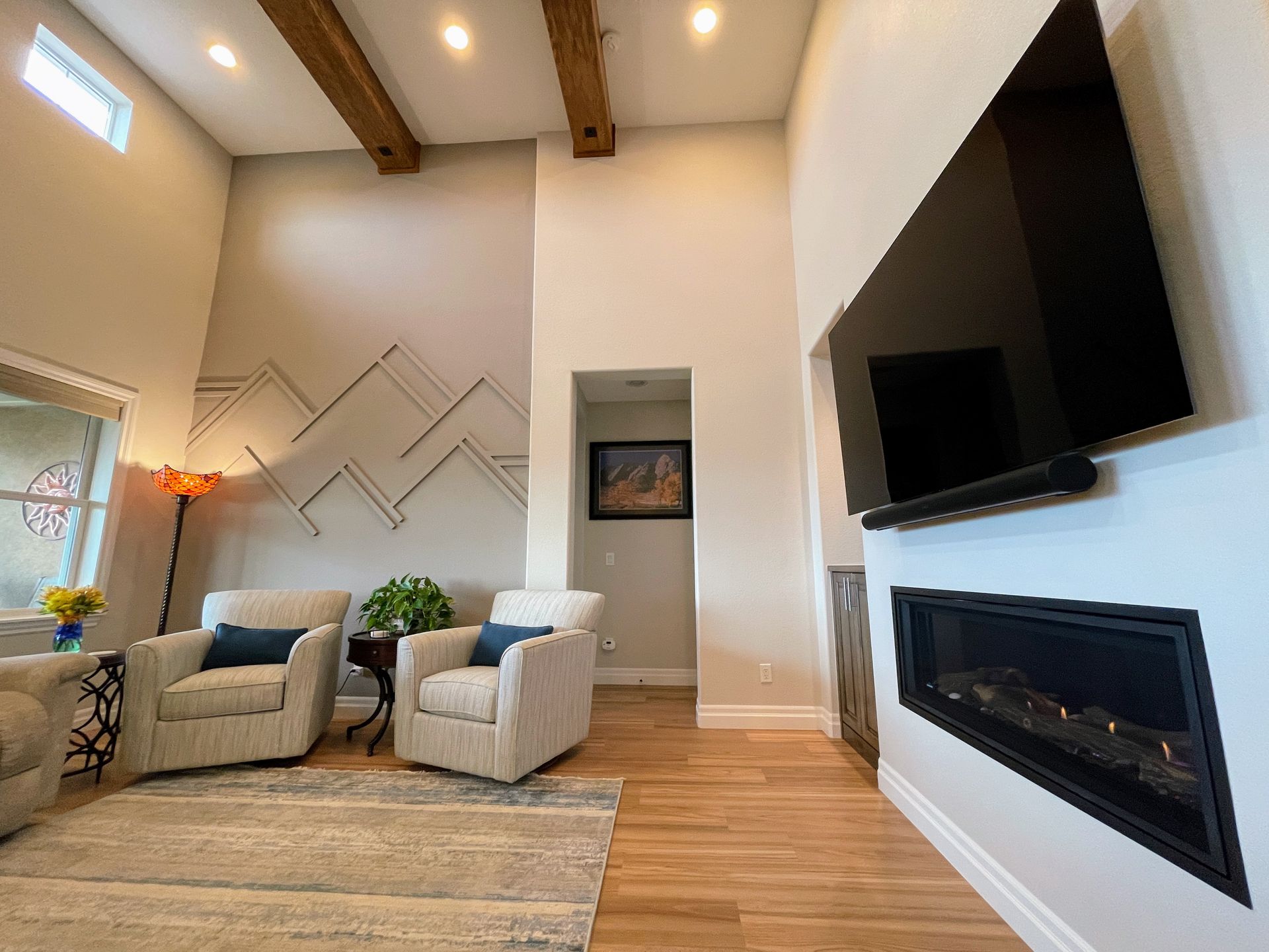 A living room with a fireplace and a flat screen tv on the wall.