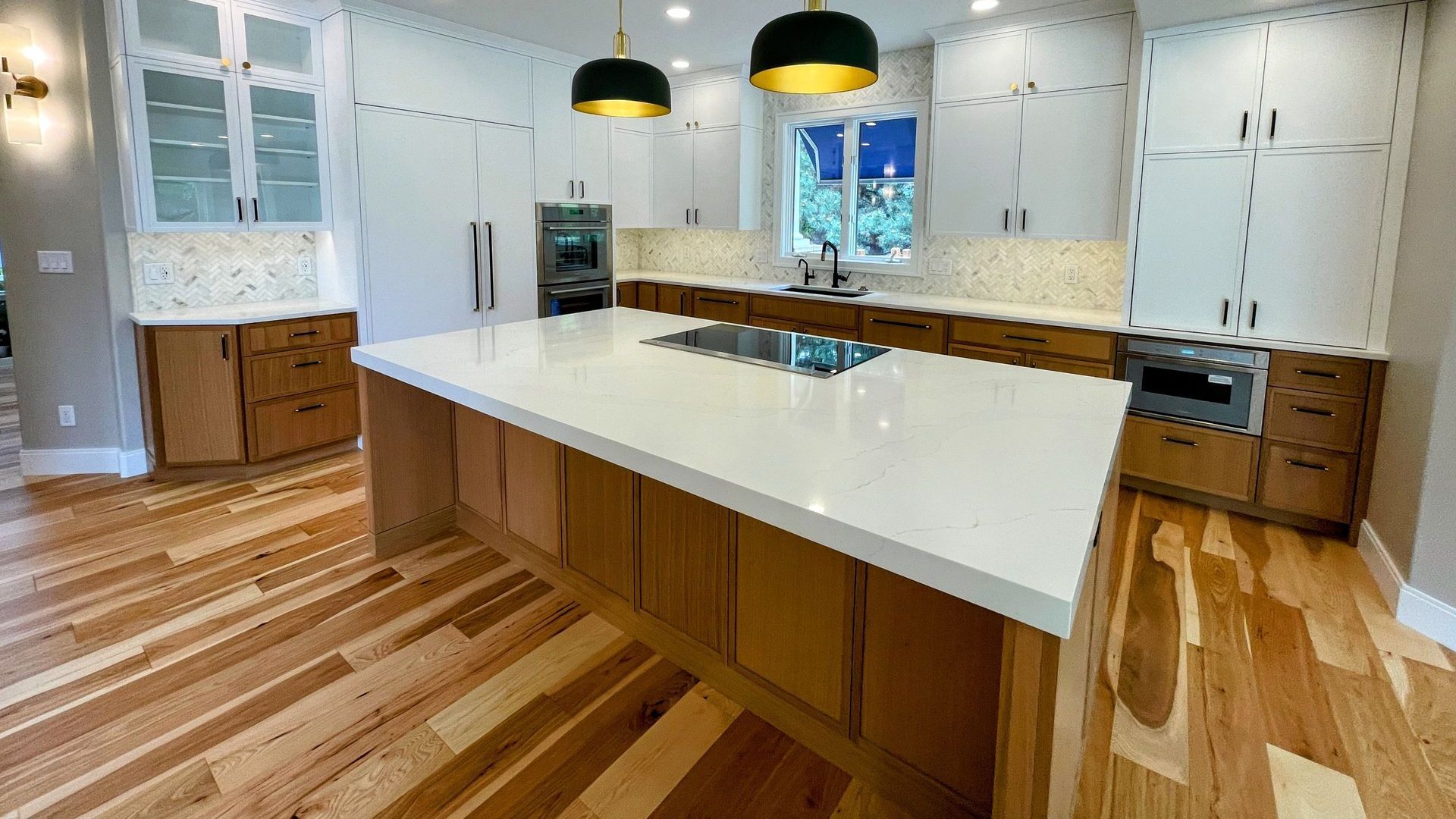 A kitchen with wooden cabinets and a large island in the middle.