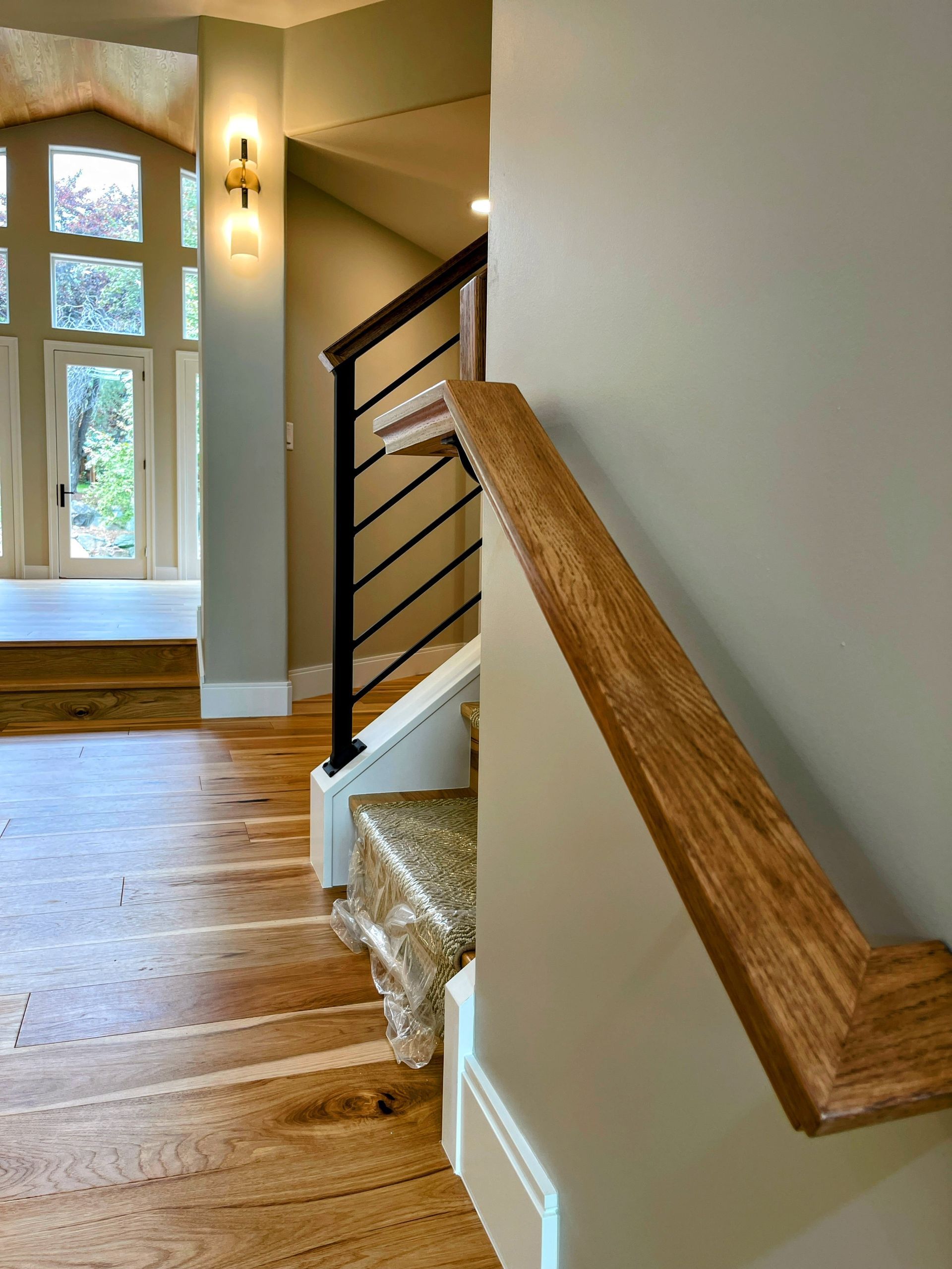 A staircase with a wooden handrail and a metal railing