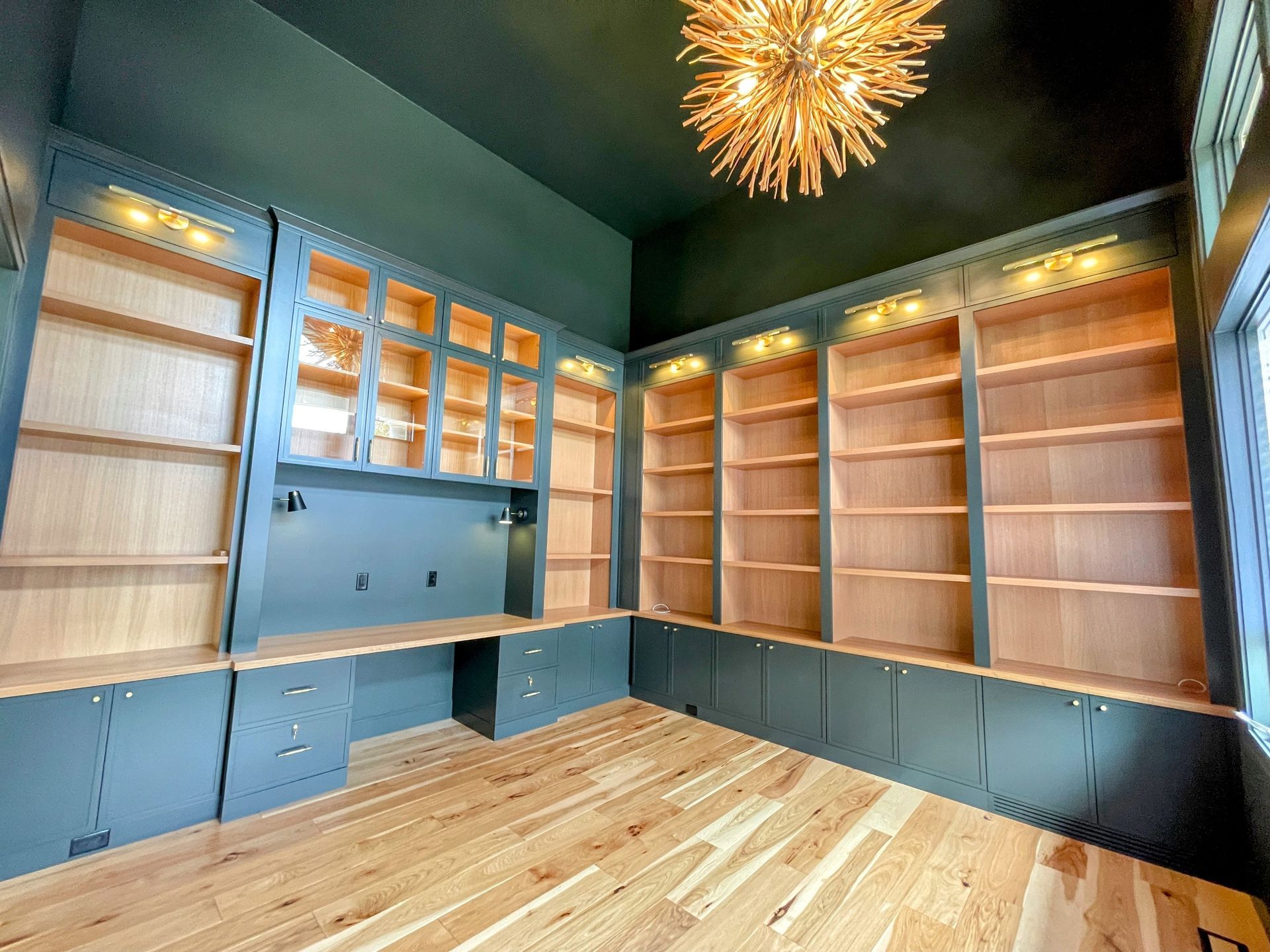 A large empty room with lots of shelves and a chandelier.