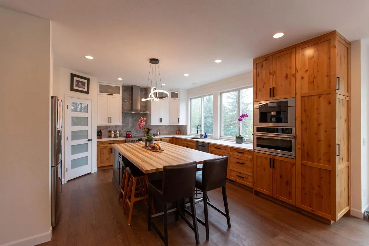 A kitchen with wooden cabinets and a large island in the middle.