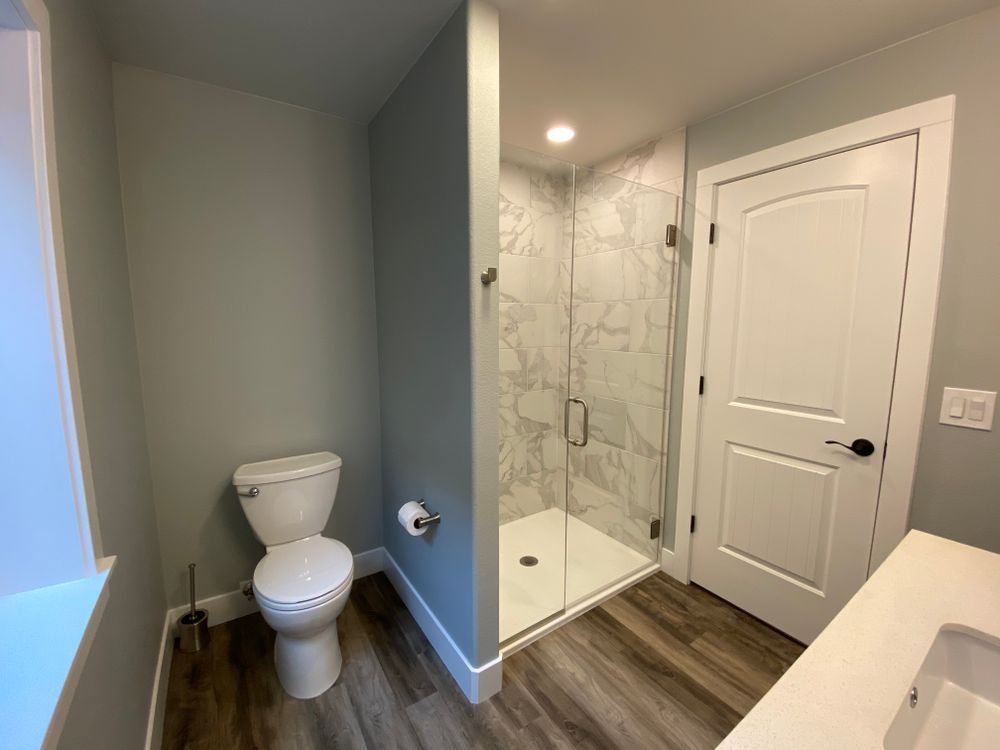 A bathroom with a toilet , sink and walk in shower.