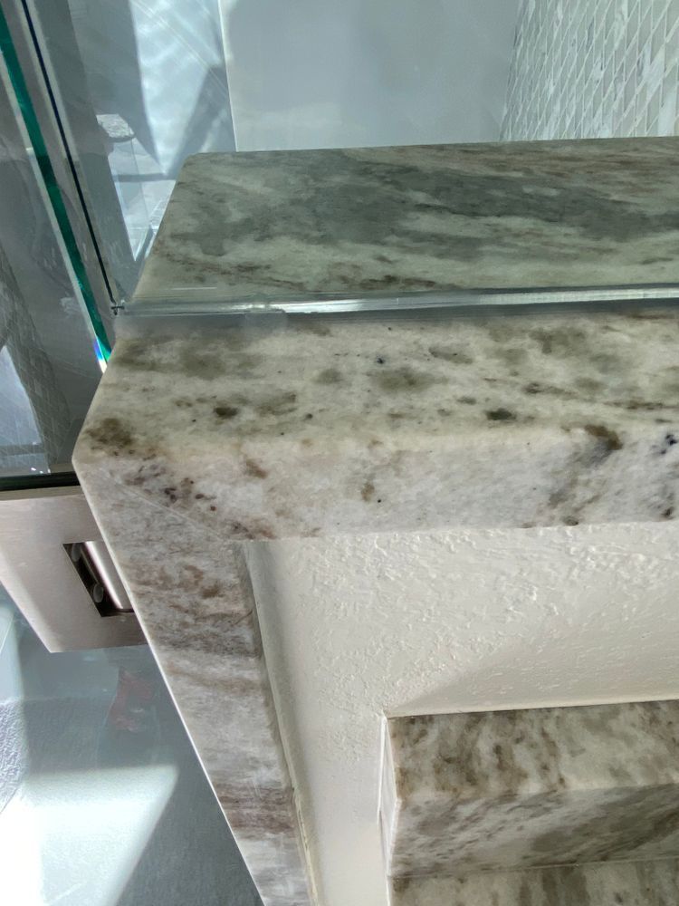 A bathroom sink with a marble counter top and a mirror.