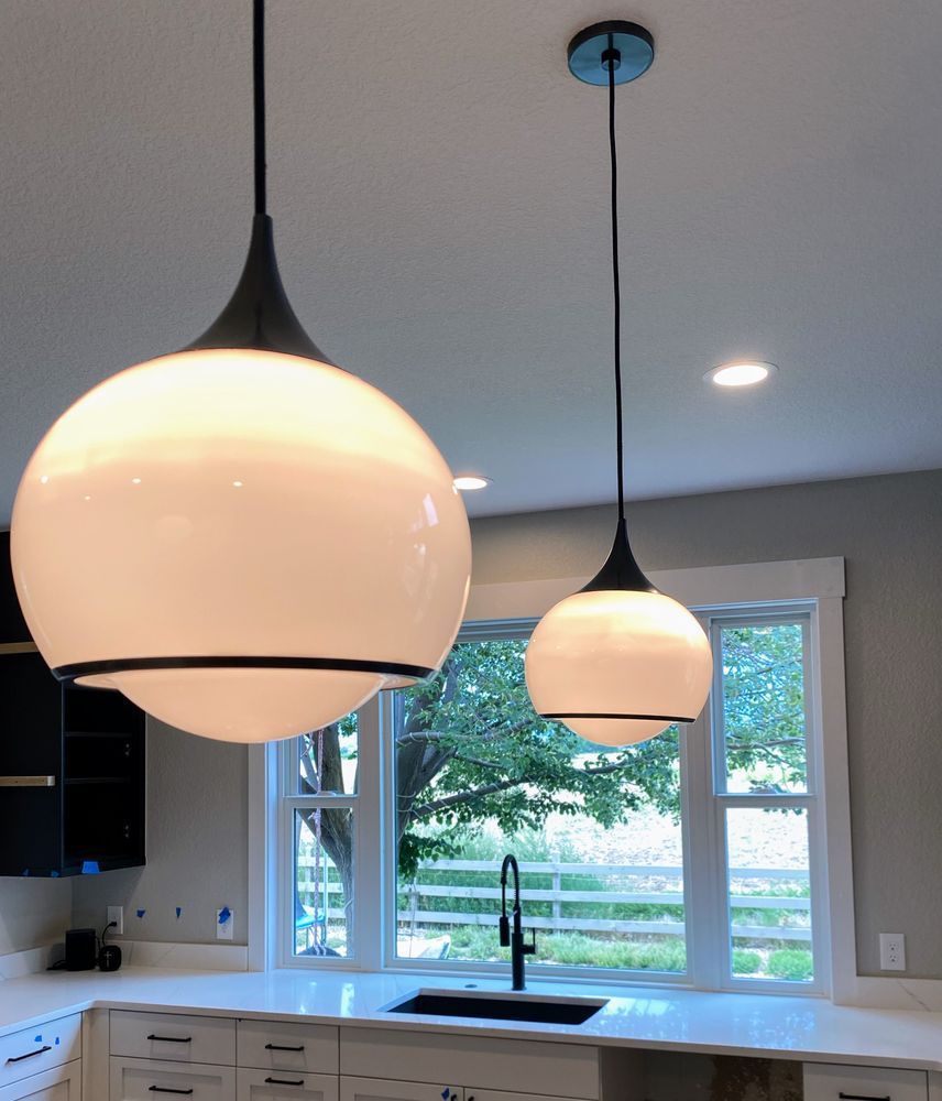 A kitchen with two pendant lights hanging from the ceiling