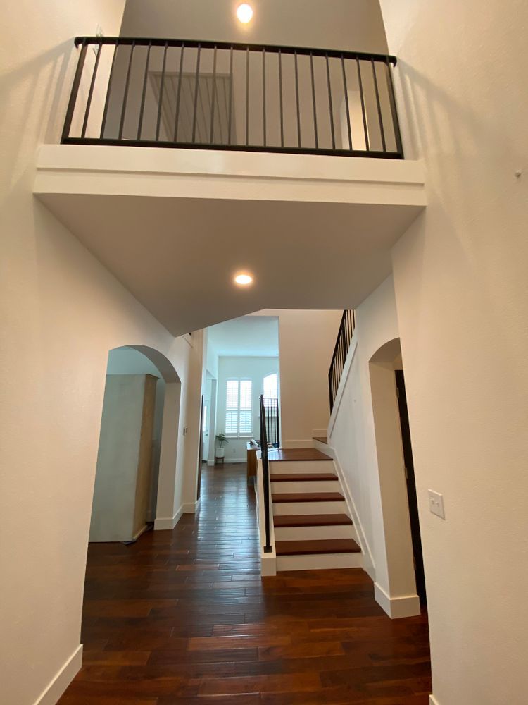 A hallway with stairs and a balcony in a house
