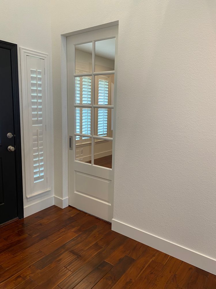 A room with hardwood floors and a glass door.