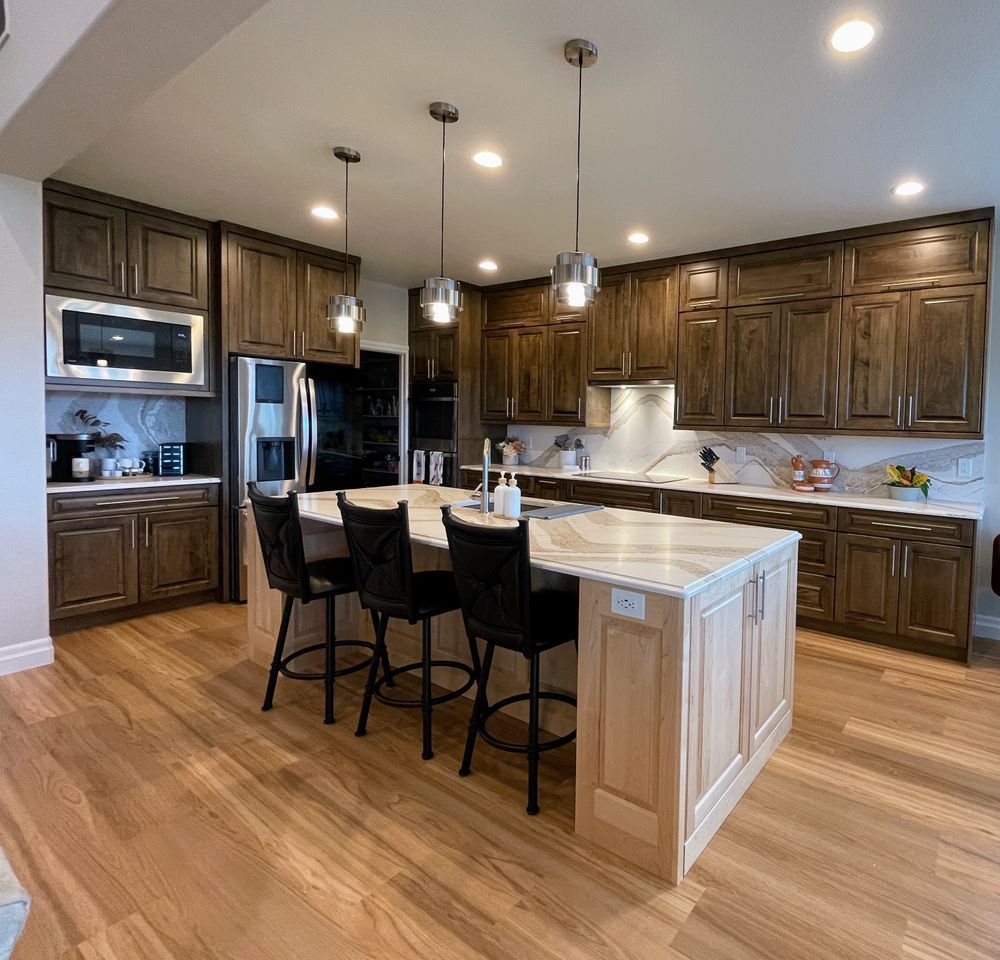A kitchen with wooden cabinets and marble counter tops