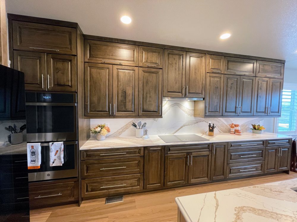 A kitchen with wooden cabinets , stainless steel appliances , a sink , and a stove.