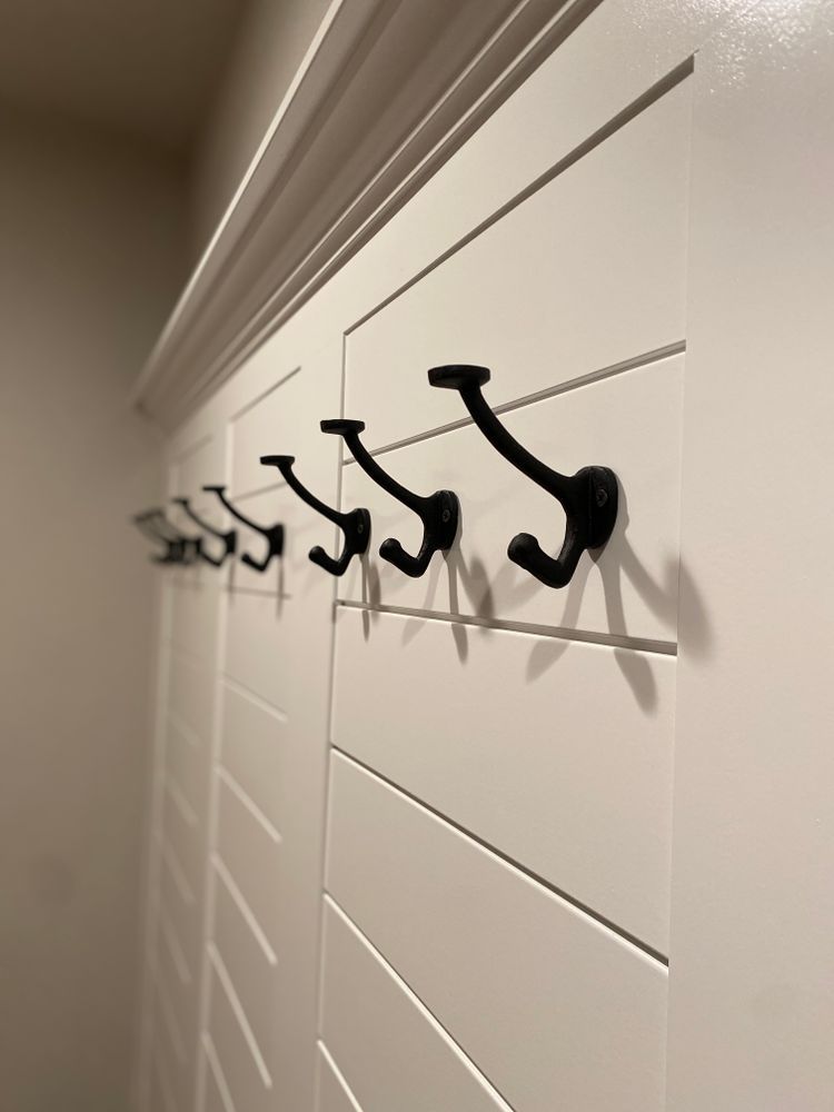 A row of black hooks on a white wall