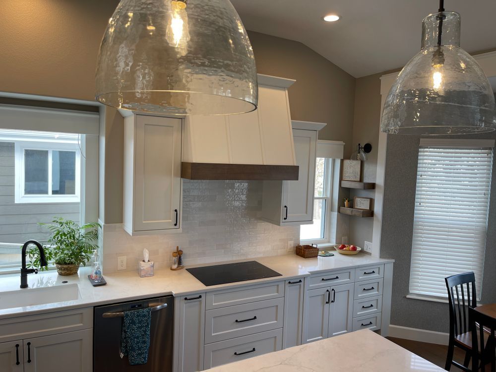 A kitchen with white cabinets and a stove top oven.