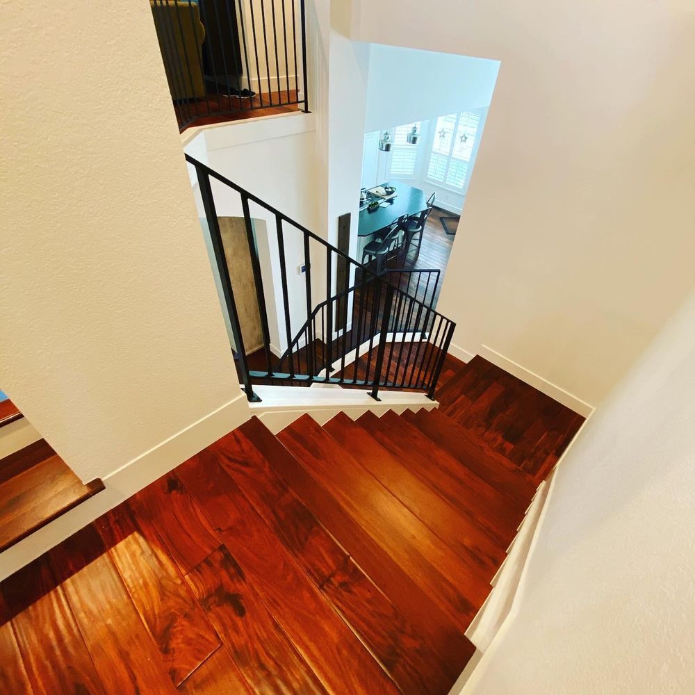 A wooden staircase with a metal railing leading up to the second floor