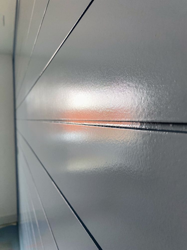 A close up of a gray wall with a few lines on it.