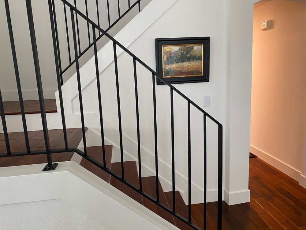 A staircase with a picture on the wall above it