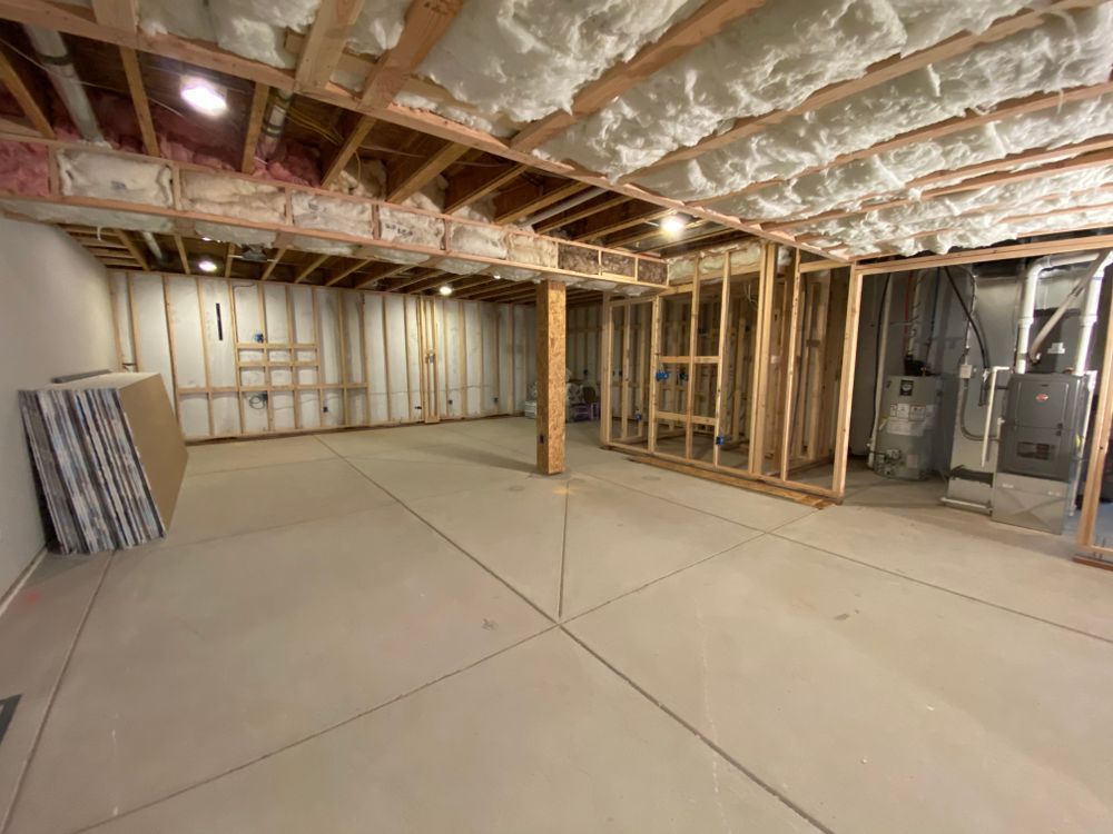 An empty basement with a lot of insulation on the ceiling and walls.