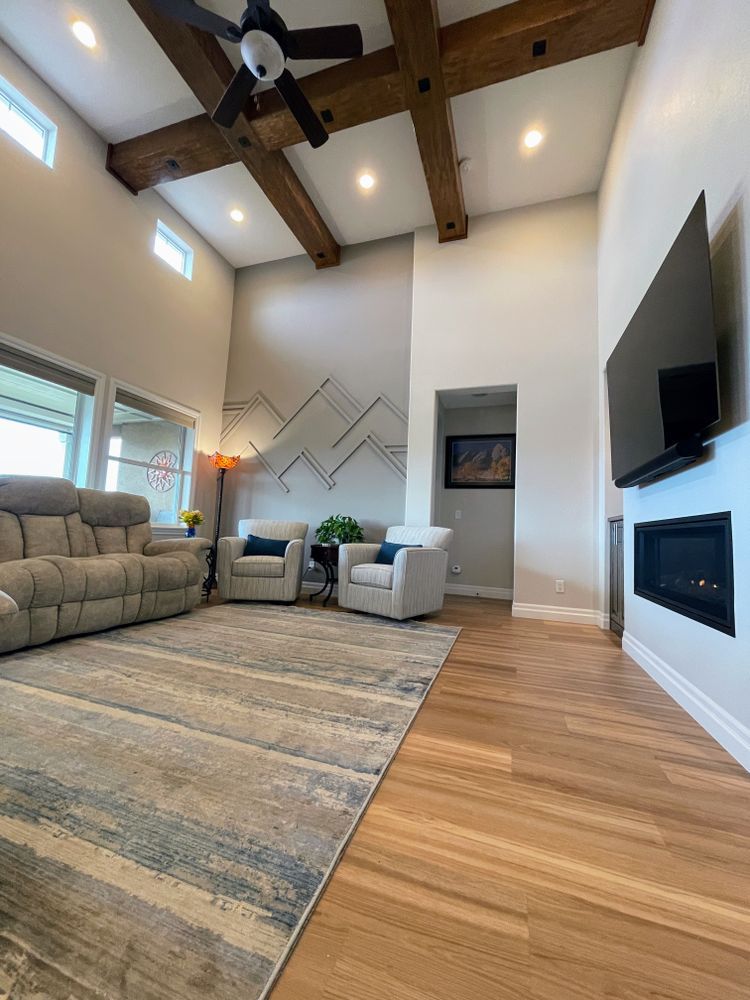 A living room with a couch , chairs , and a flat screen tv.