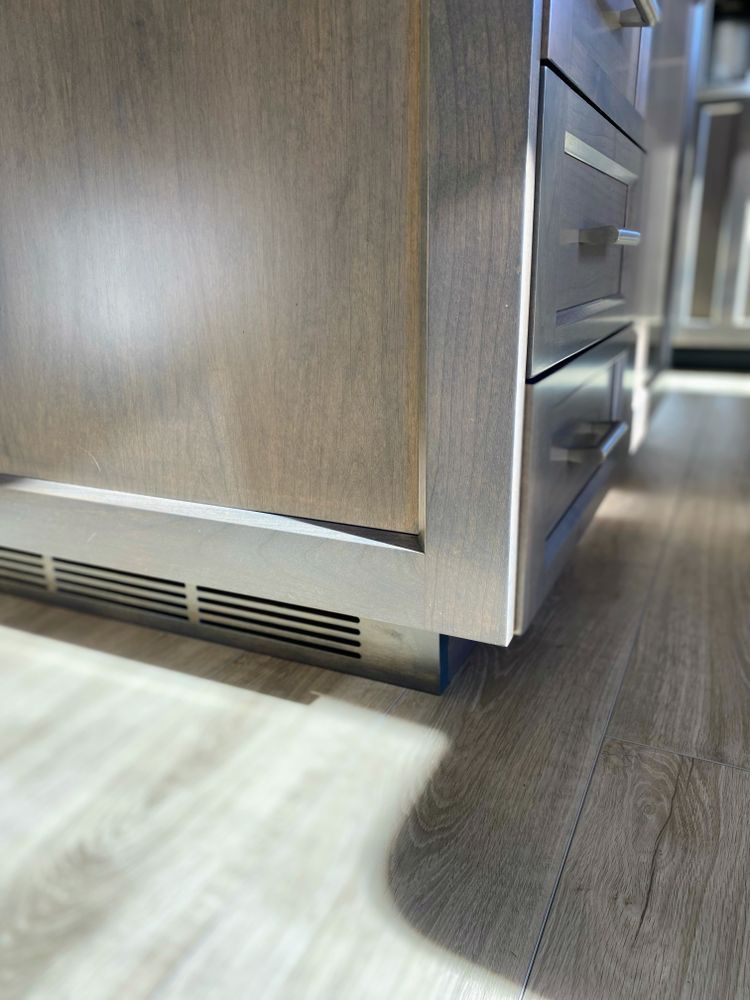 A kitchen with stainless steel cabinets and wooden floors