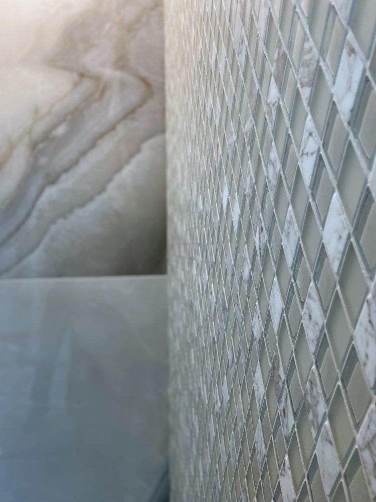 A bathroom with a sink and a tiled wall.