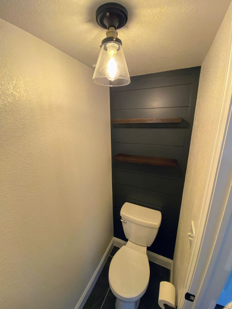 A bathroom with a toilet and a light on the ceiling.