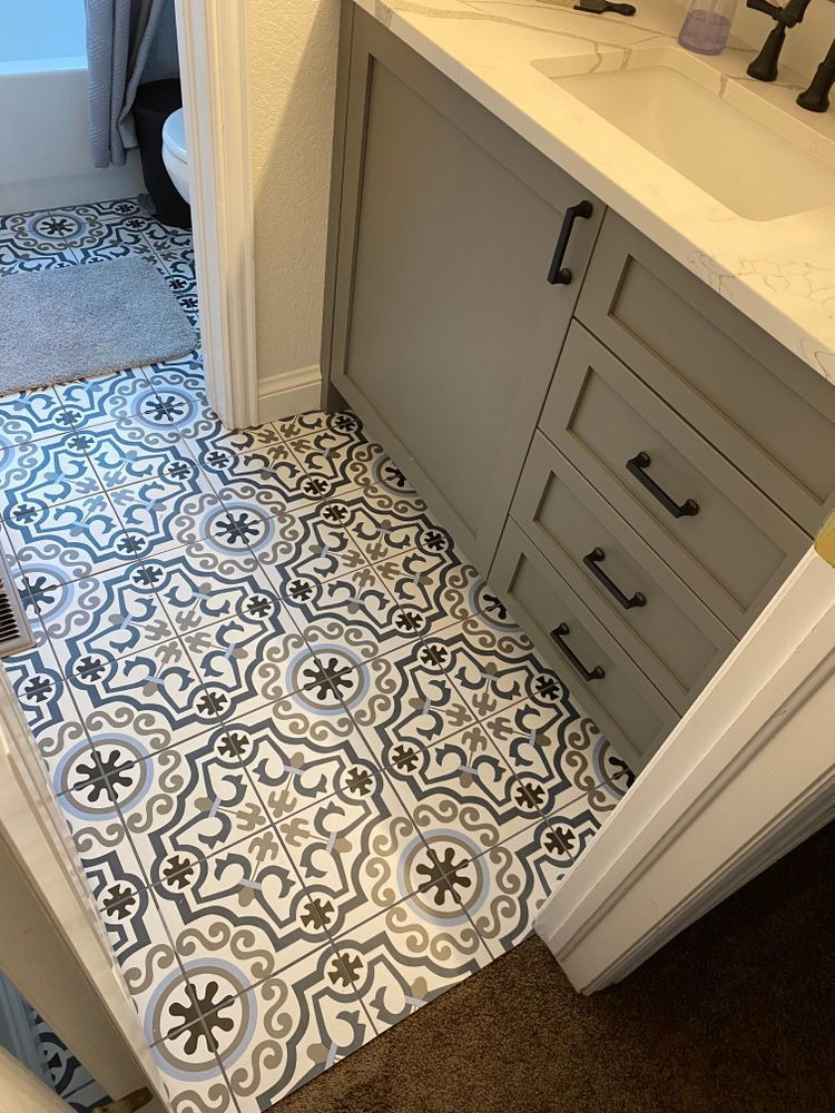 A bathroom with a tiled floor and a sink